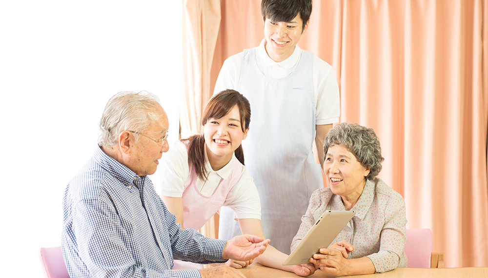 高齢の男性にタブレットを見せている様子