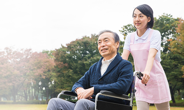 車椅子の男性と散歩する様子