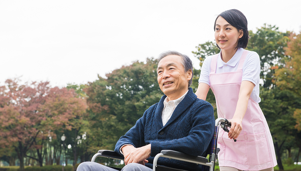 車椅子の男性と散歩する様子